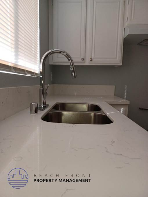 a white counter top with a sink in a kitchen