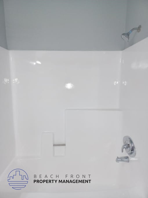 a white bathroom with a shower and a sink