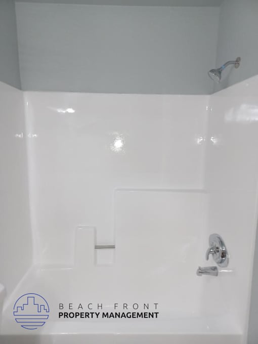 a white bathroom with a shower and a sink