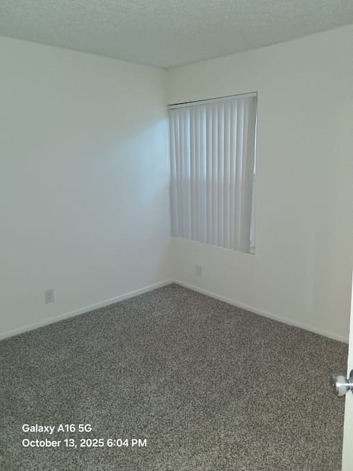 A room with a window covered by blinds.