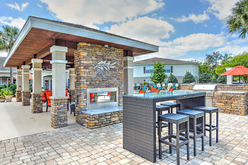 A patio with a bar and stools.