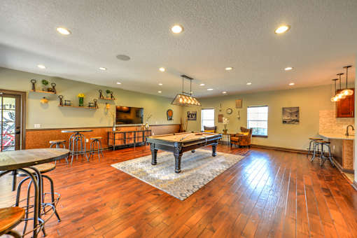 A large open room with wooden floors and a long table.