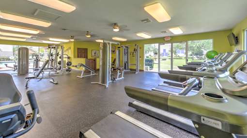 A gym with treadmills, weights, and exercise equipment.