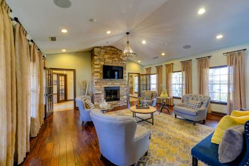 A living room with a stone fireplace and a television above it.