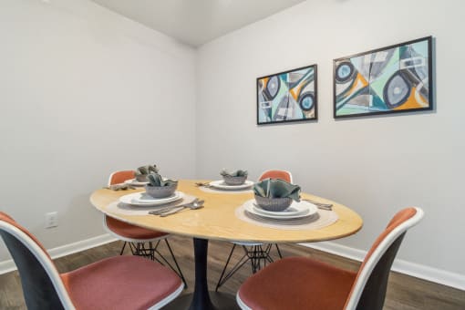 a dining room with a table and chairs and paintings on the wall