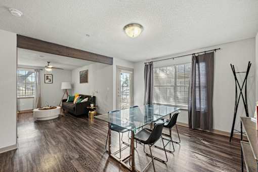 A living room with a glass table and chairs.