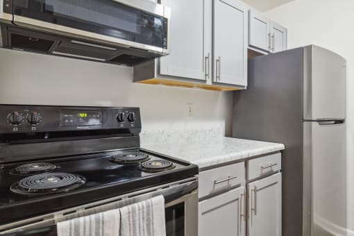 a kitchen with white cabinets and a stove and a refrigerator