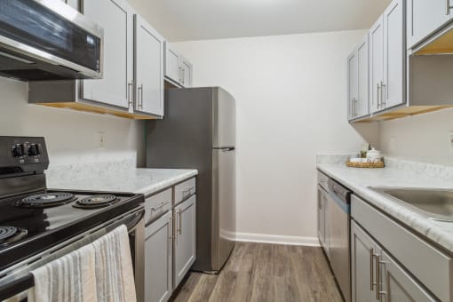 a kitchen with white cabinets and stainless steel appliances and a stainless steel refrigerator