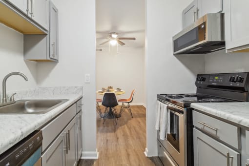 a kitchen with white cabinets and stainless steel appliances and a dining room with a table