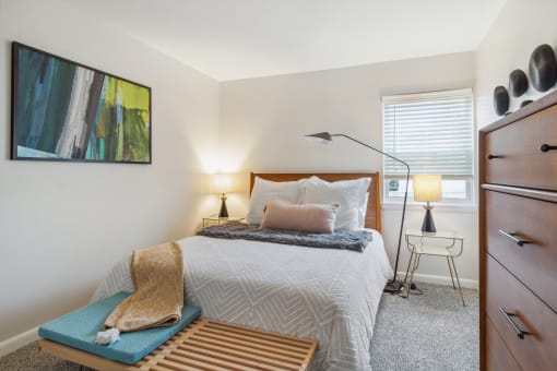 a bedroom with a bed and a dresser and a window