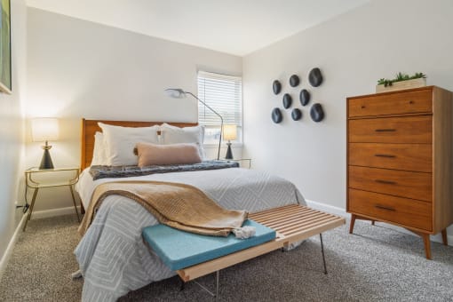a bedroom with a bed and a dresser and a window