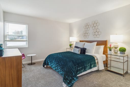 a bedroom with a bed and a desk and a window