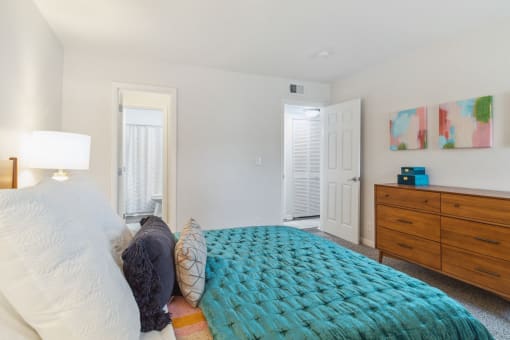 a bedroom with a bed and a dresser and a closet