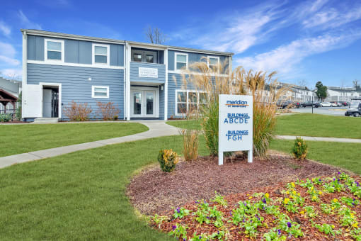 a blue building with a white sign in front of it