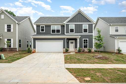 A grey house with a white garage door in front.