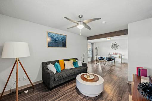 A living room with a grey couch and a wooden floor.