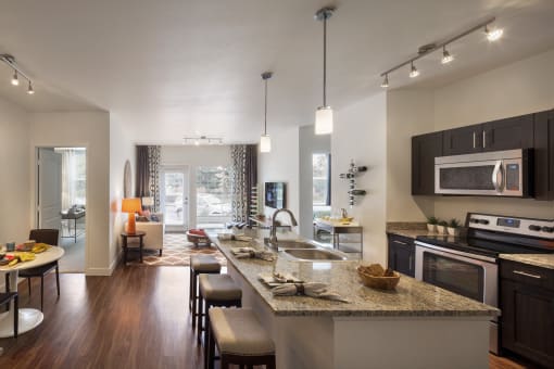 a kitchen and living room with a large granite counter top