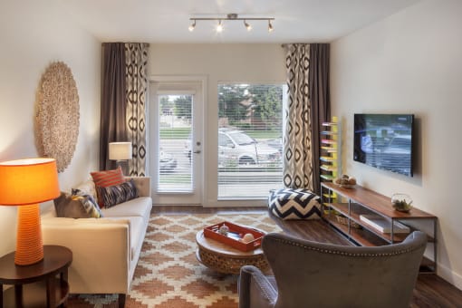 a living room with a couch and a chair and a television