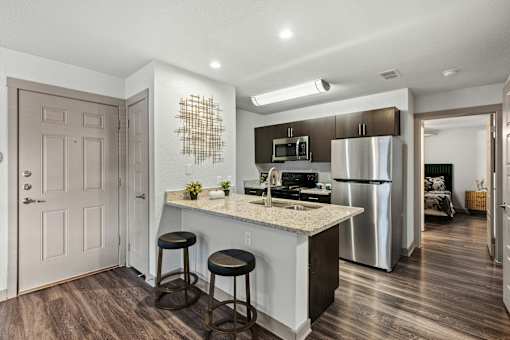 A kitchen with a bar stool and a counter.