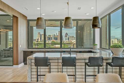 A modern kitchen with a marble countertop and a view of the city.