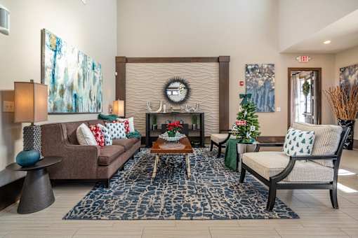 A living room with a brown couch, a coffee table, and a fireplace.
