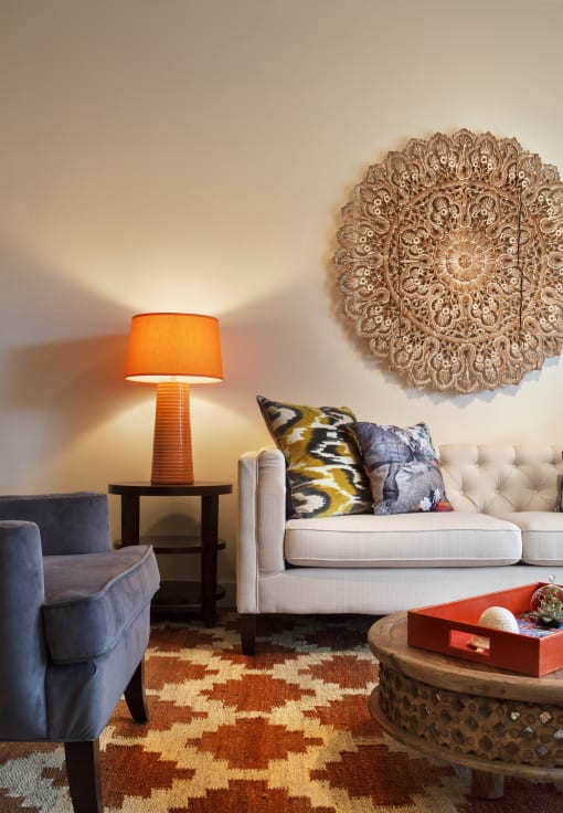 a living room with a couch and a chair and a lamp
