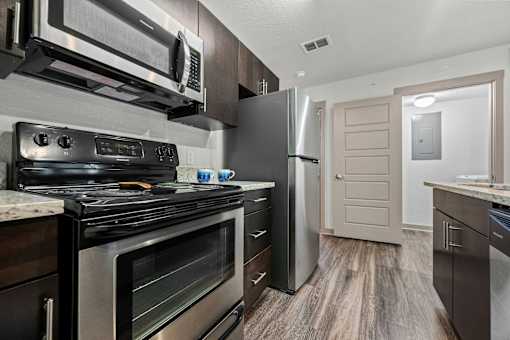 A modern kitchen with a stainless steel refrigerator and oven.