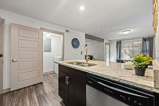 A kitchen with a black dishwasher and a sink.