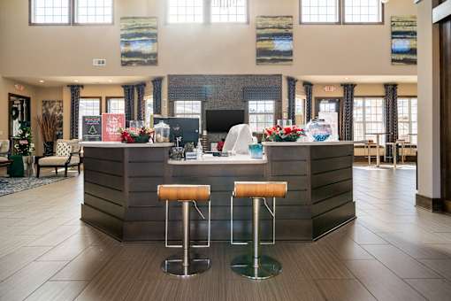 A reception area with a bar and two stools.