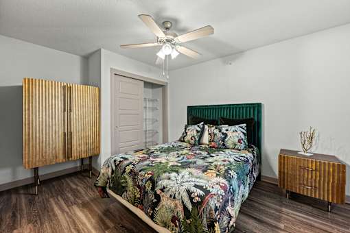 A bedroom with a bed, a wooden cabinet, and a ceiling fan.