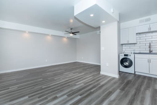 an empty living room with a washer and dryer in it