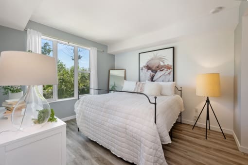 a bedroom with a large bed and two windows