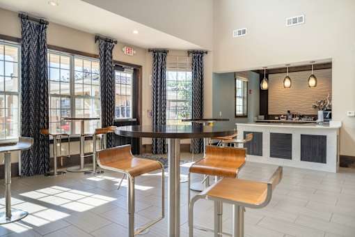 A modern dining area with a bar and chairs.