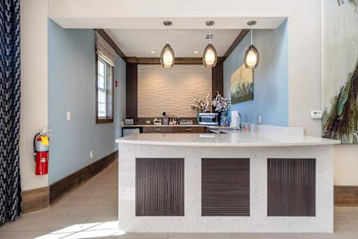 A reception area with a white counter and brown shades.