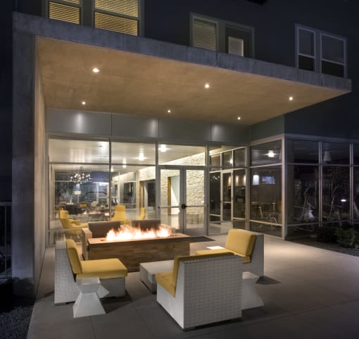 a fire pit in the middle of a patio with chairs and tables