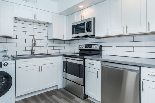 a kitchen with white cabinets and stainless steel appliances