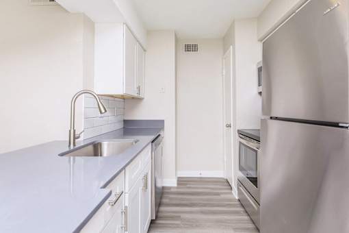 A kitchen with a sink and a refrigerator.