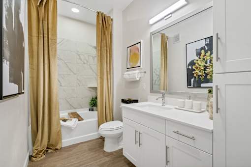 A bathroom with a white toilet, sink, and a marble wall.