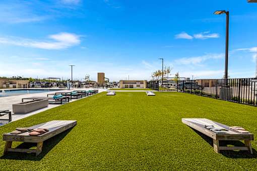 A grassy area with benches and a fence in the background.