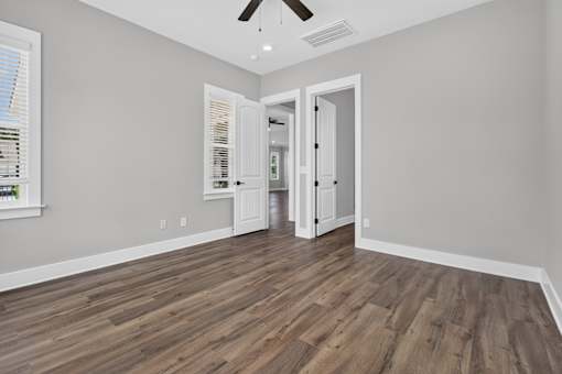 A room with a wooden floor and a ceiling fan.