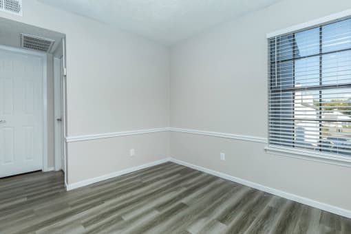 a bedroom with gray walls and a window with blinds