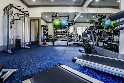 a gym with cardio machines and weights on the floor