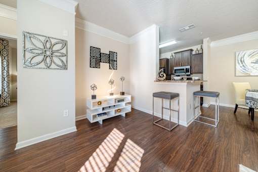 A kitchen area with a bar and stools.