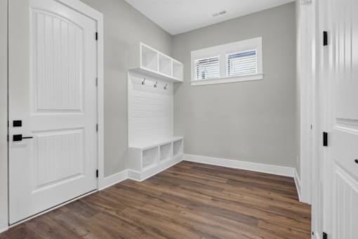 A room with a white door and a wooden floor.