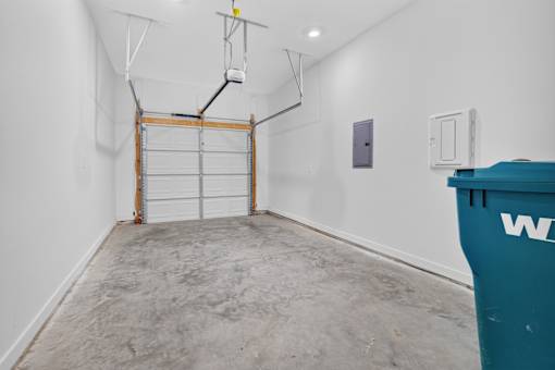 A room with a white wall and a blue dumpster.