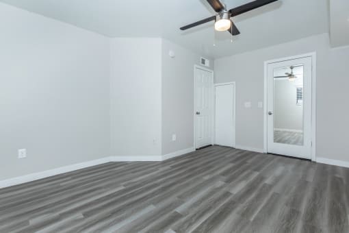 the living room of an empty house with a ceiling fan