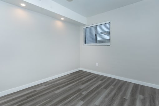 an empty room with white walls and a window
