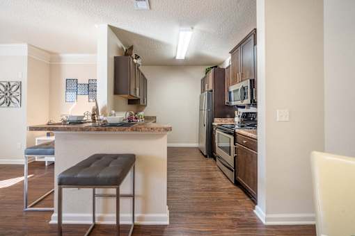 A kitchen with a bar stool in front of it.