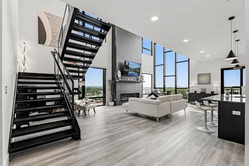 A modern living room with a staircase and a flat screen TV.