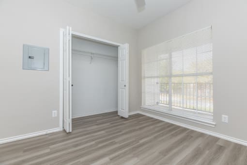 a bedroom with a large window and a closet